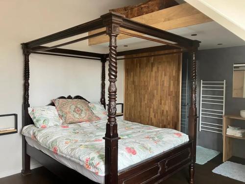 a bedroom with a canopy bed in a room at De Logeerkamer in Udenhout