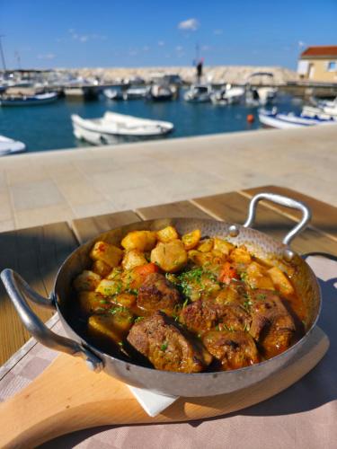 a pan of food on a table near a marina at Hotel Marina in Fažana