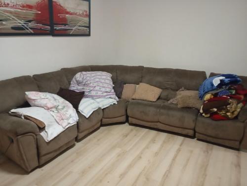 a brown couch with blankets and pillows on it at Padina-Kovacica in Padina