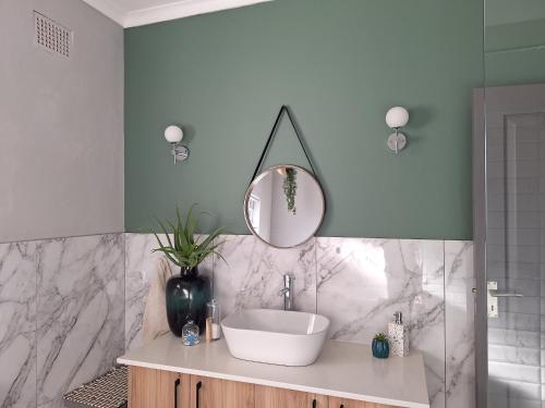 a bathroom with a sink and a mirror at 1 CAMDEBO in Oudtshoorn