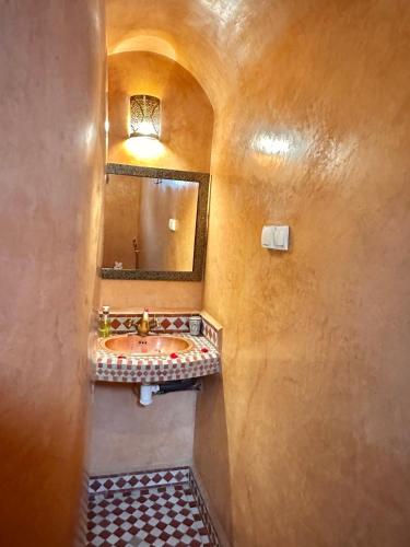 a bathroom with a sink and a mirror at Riad Tasneem in Marrakech