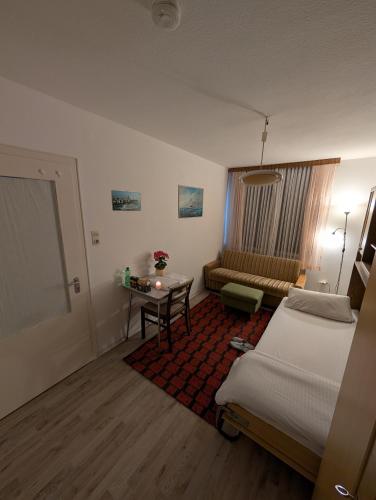 una camera d'albergo con letto, tavolo e divano di Affordable room in Bremerhaven a Bremerhaven
