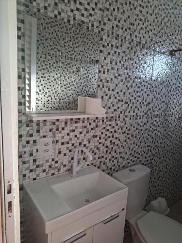 a bathroom with a sink and a toilet and a mirror at KIT Rayar in Alto Paraíso de Goiás