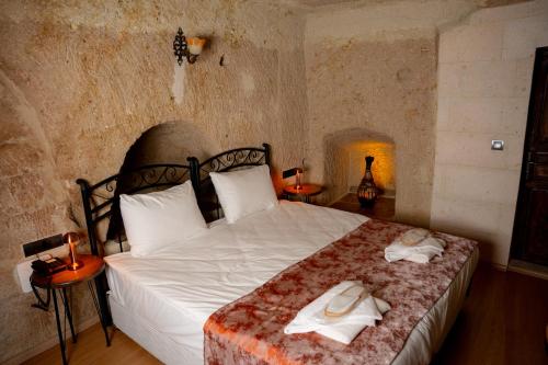 a bedroom with a bed with towels on it at Colina Stone House in Mustafakemalpaşa