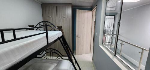Una pequeña habitación con una litera y una ventana. en Hermosa casa en Montebonito, Dosquebradas, en Dosquebradas