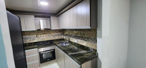 Una cocina con gabinetes de madera y encimera. en Hermosa casa en Montebonito, Dosquebradas, en Dosquebradas