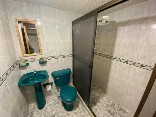 a bathroom with a blue toilet and a shower at CASA MAGIA by Magally Velasco in Curití
