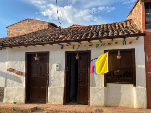 a house with two doors and a flag on it at CASA MAGIA by Magally Velasco in Curití