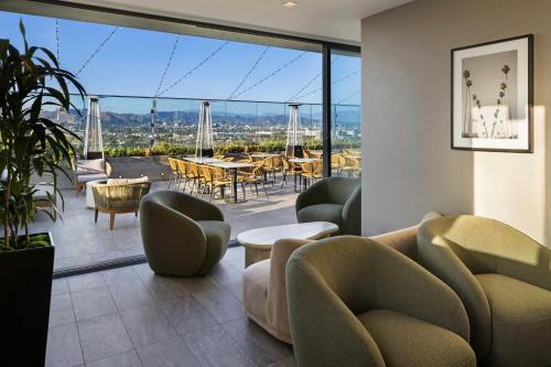 a lobby with chairs and tables and a large window at AC Hotel by Marriott Beverly Hills in Los Angeles