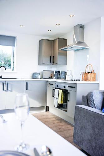 a white kitchen with a couch and a table at Kingfisher in Pembrokeshire