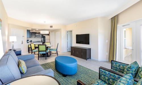 a living room with a blue couch and a tv at Vacation Village Orlando, Celebration in Orlando