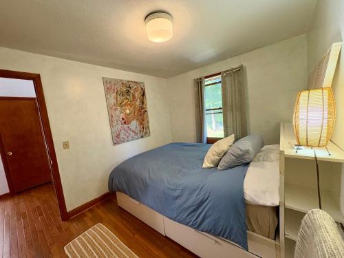 a bedroom with a blue bed and a window at Room in a home in Narragansett