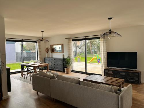 a living room with a couch and a television and a table at Maison 3 chambres in Changé