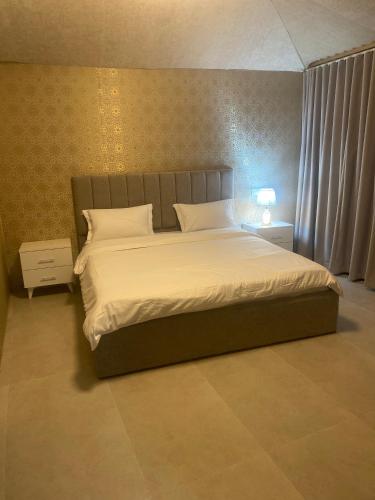 a bedroom with a large bed with white sheets at Valley View Wadi Bani Khalid in Dawwah