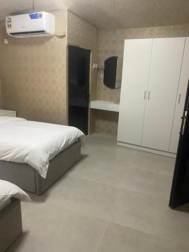 a room with two beds and a refrigerator and a kitchen at Valley View Wadi Bani Khalid in Dawwah