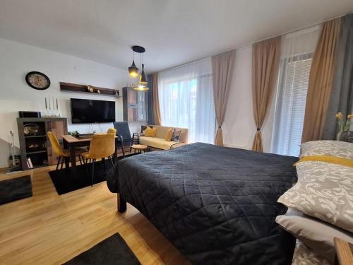 a bedroom with a bed and a living room at ТРИ ПЛАНИНИ ап113 in Razlog