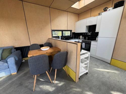 a kitchen with a table and chairs in a room at The Timber Lodge - Sennen Holiday Home in Sennen
