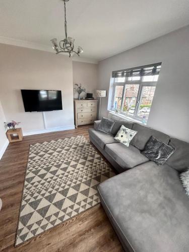 a living room with a couch and a television at Denzels Den Apartment 2 in Llandudno Junction