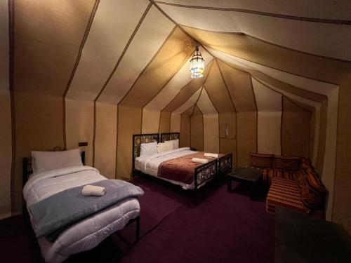 a room with two beds in a tent at Merzouga Majestic Camp in Merzouga