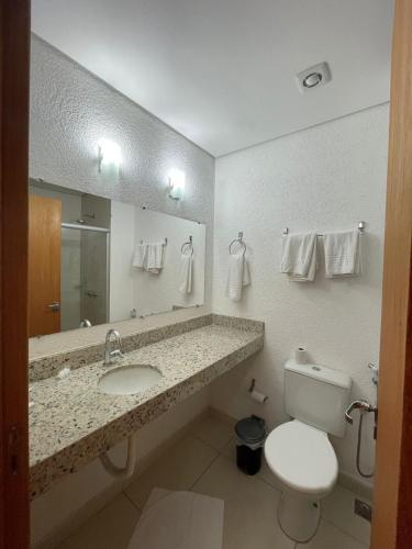 ein Badezimmer mit Waschbecken, Toilette und Spiegel in der Unterkunft Hotel 494 Oliveira-MG in Oliveira
