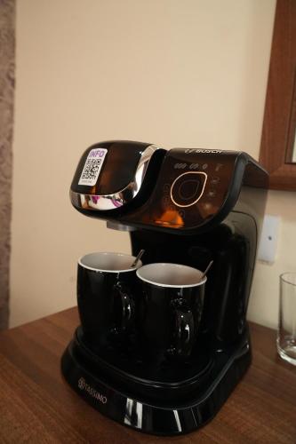 a coffee maker with two espresso cups on a table at The Continental Hotel, Derby in Derby