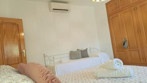 a white bedroom with a bed with a white towel at LabellaCasona in Quéntar