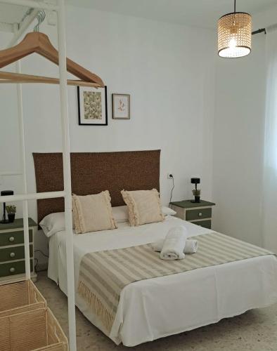 a bedroom with a white bed with a wooden frame at LabellaCasona in Quéntar