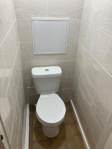 Un baño con un inodoro blanco en una cabina. en Apiņa 18, en Valmiera
