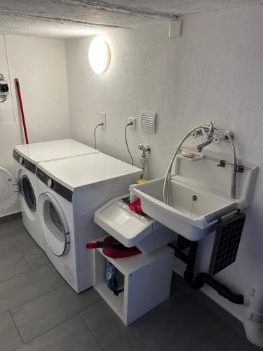 a bathroom with a washing machine and a sink at Guest House 6646 in Contra