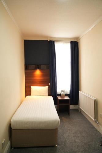 a bedroom with a bed and a window at The Continental Hotel, Derby in Derby