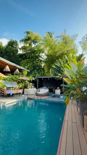 a swimming pool with chairs and a table at Villa Marii in Dipolog