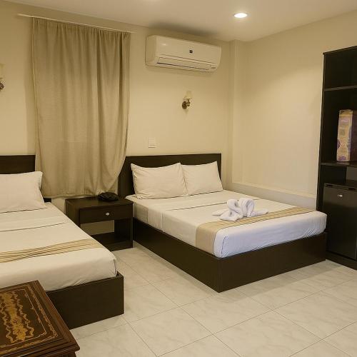 a hotel room with two beds and a window at Ramses Pyramids INN in Cairo