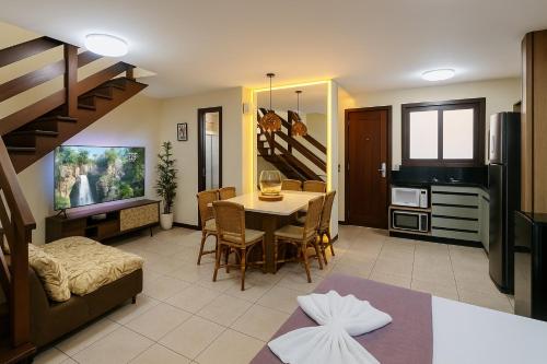 Una sala de estar con una mesa de comedor y una cocina. en Solar de Pipa Elegance Duplex Flat, en Pipa