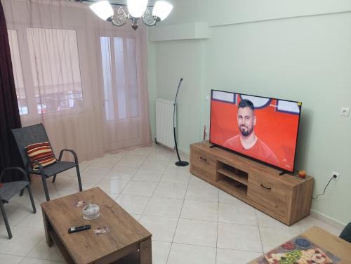 a living room with a flat screen tv on a wooden entertainment center at IRIS apartment in Sparti