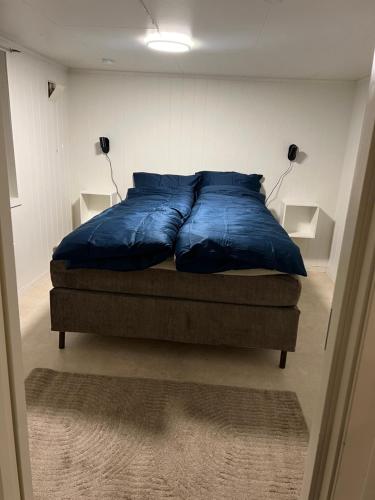 een groot blauw bed in een kamer met 2 lampen bij Tromsø Stay in Tromsø