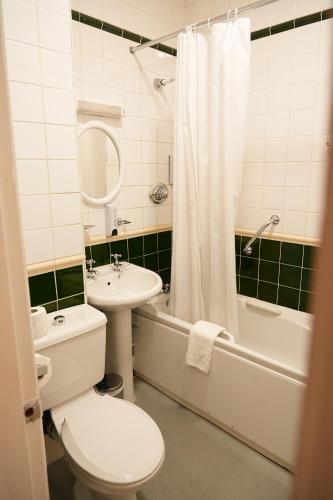 a bathroom with a toilet and a sink and a shower at The Continental Hotel, Derby in Derby