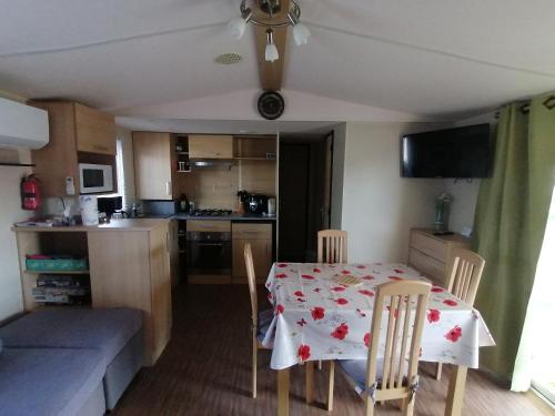 a kitchen and dining room with a table and chairs at Mobilhome Vendée Océan in Brem-Sur-Mer