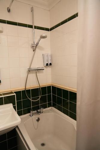 a bathroom with a bath tub and a sink at The Continental Hotel, Derby in Derby
