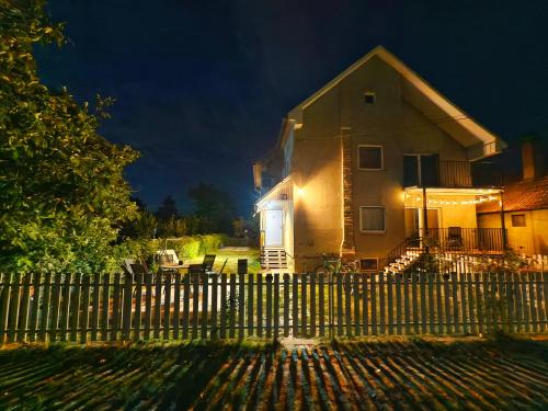 a house with a fence in front of it at Hedonists Paradise in Omoljica