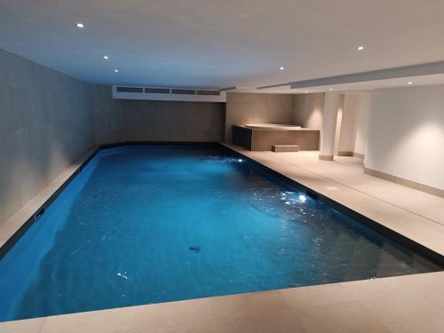 una piscina con agua azul en un edificio en ELBA, Les Mazots de Kayla, en Les Houches