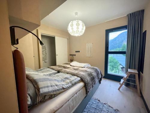 Un dormitorio con una cama y una ventana grande. en ELBA, Les Mazots de Kayla, en Les Houches