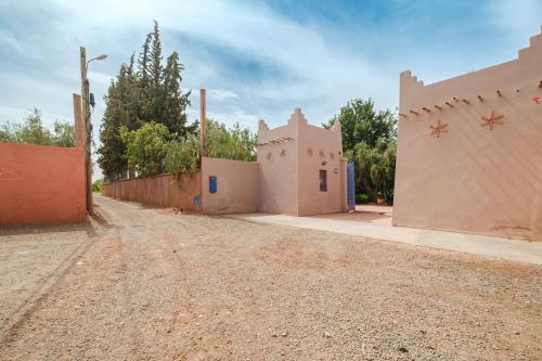 an empty dirt road in a village with buildings at Dar Salah - Eddine Oasis Pool & SPA in Oulad Mazoug