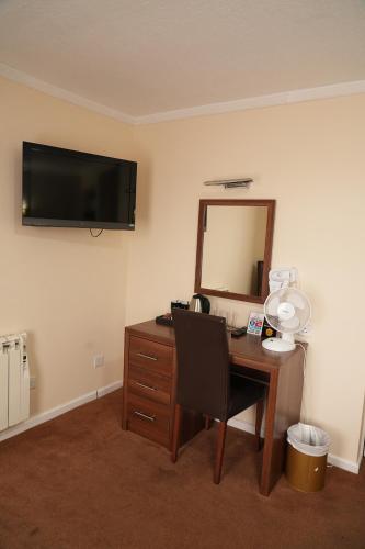 a room with a desk with a mirror and a desk sidx sidx sidx at The Continental Hotel, Derby in Derby