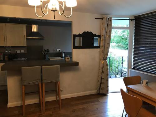a kitchen with a counter and a table with chairs at 2 new bold lawns leamington spa in Moffat