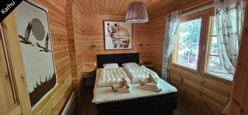 una camera da letto con un letto in una stanza di legno di Quiet Lakeside Forest Escape a Virasoja