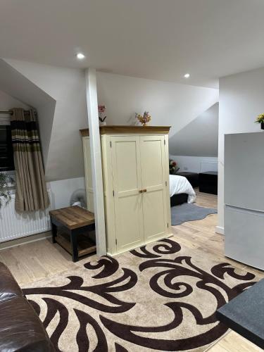 a living room with a couch and a rug at A Cosy and Spacious Studio Flat in Navestock