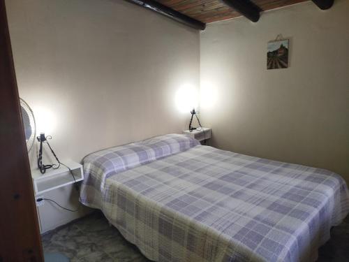 ein Schlafzimmer mit einem Bett und zwei Lampen an der Wand in der Unterkunft Departamento Manna in Alta Gracia