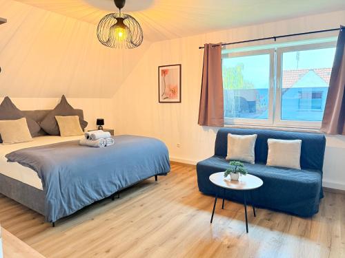 a bedroom with a blue bed and a couch at Ferienwohnung DanVie in Varel