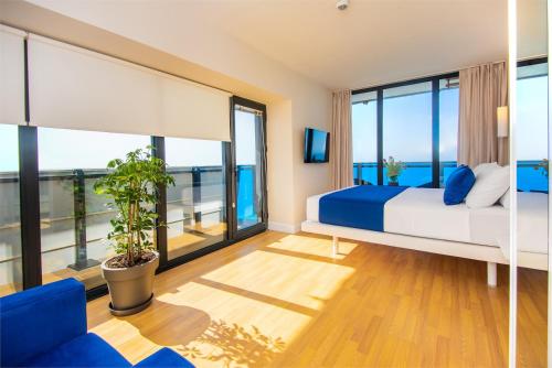 バトゥミにあるBlack Sea View Resort Hotelのベッドと大きな窓のある寝室