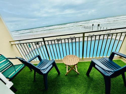 Un balcón con dos sillas y una mesa y el mar. en Direct Oceanfront Coastal Bliss, en Daytona Beach